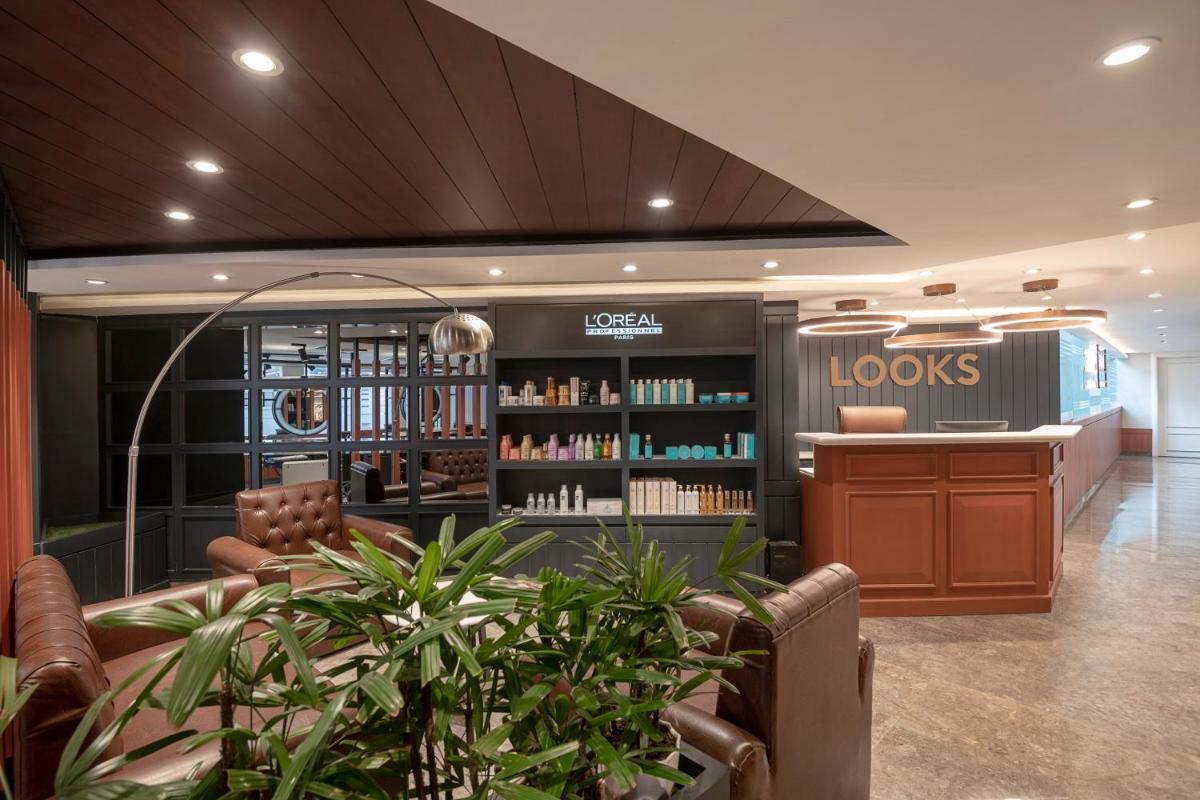 a library with a waiting room with a book shelf at Radisson Blu Kaushambi Delhi NCR in Ghaziabad