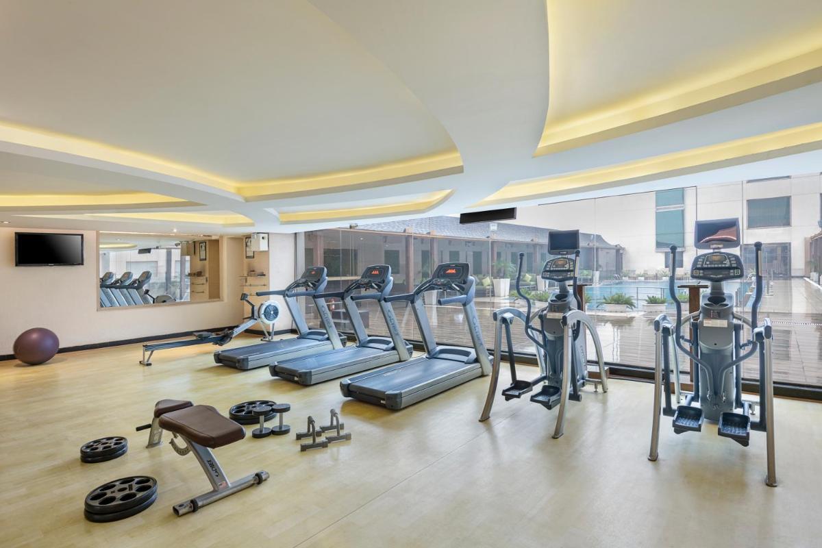 a gym with treadmills and cardio equipment in a building at Radisson Blu Kaushambi Delhi NCR in Ghaziabad