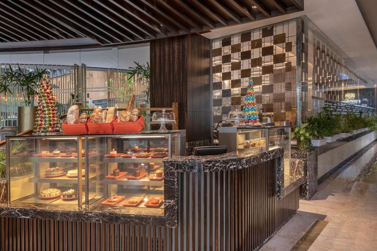 a bakery with a christmas tree and a display case at Radisson Blu Kaushambi Delhi NCR in Ghaziabad