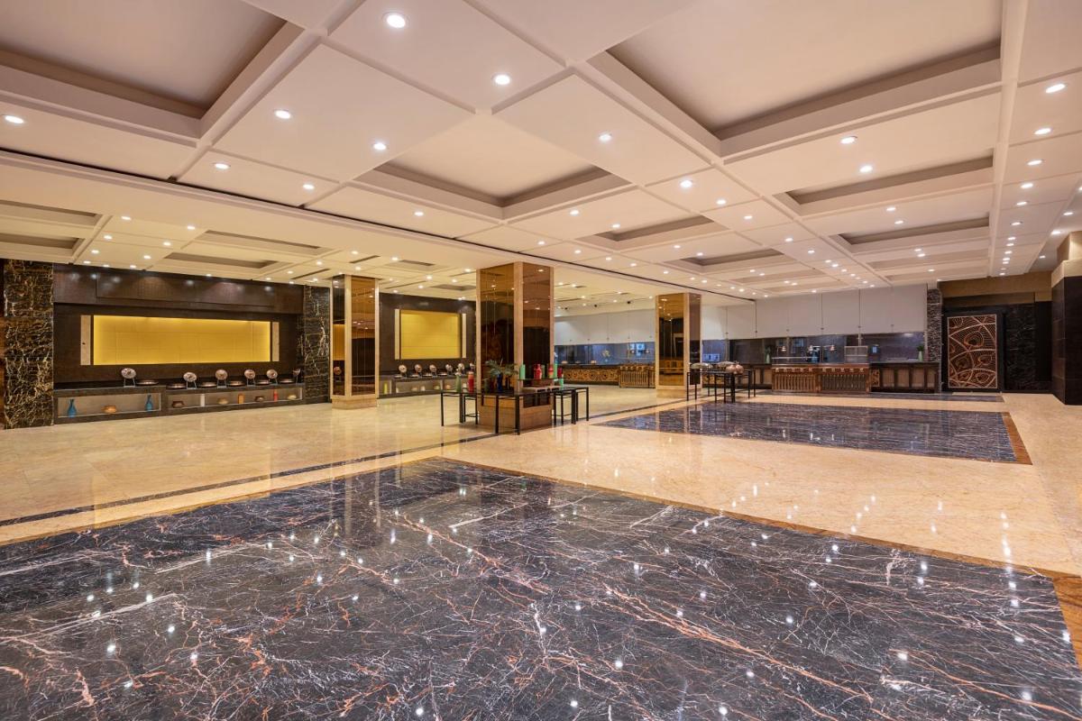 a large lobby with a marble floor and a bar at Radisson Blu Kaushambi Delhi NCR in Ghaziabad