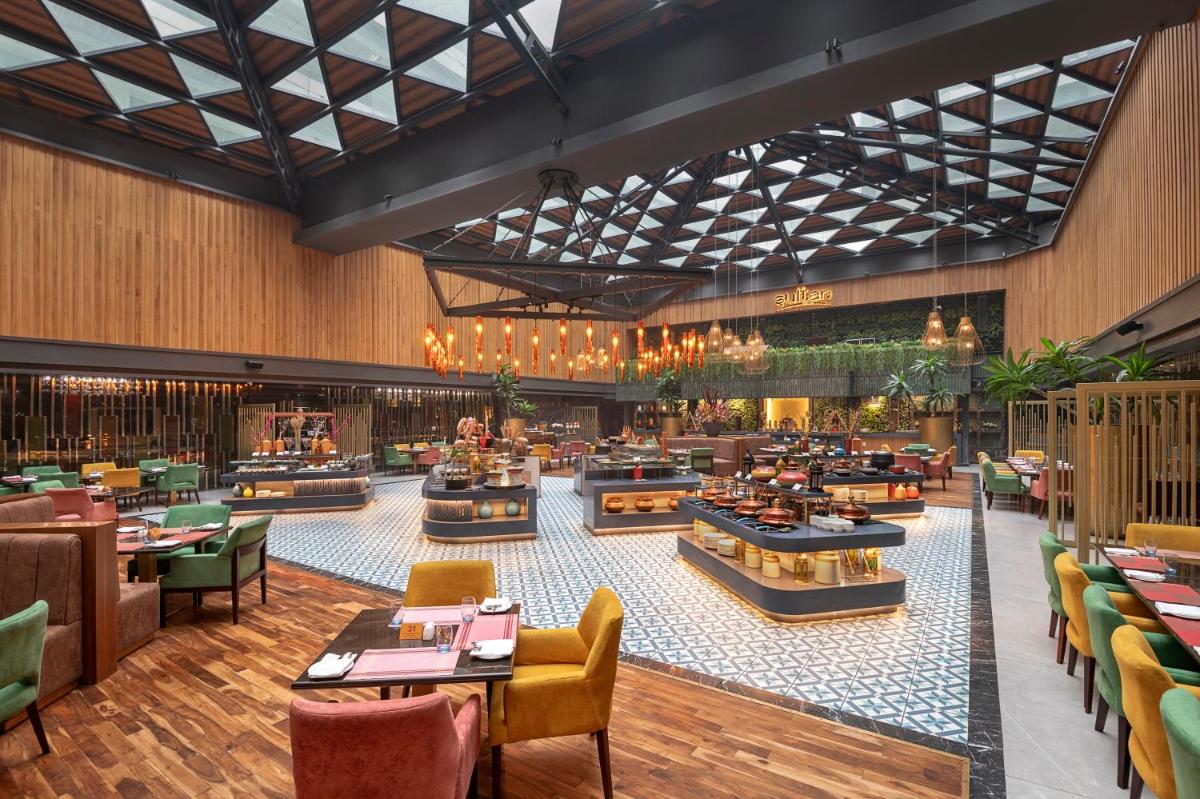 a rendering of a restaurant with tables and chairs at Radisson Blu Kaushambi Delhi NCR in Ghaziabad