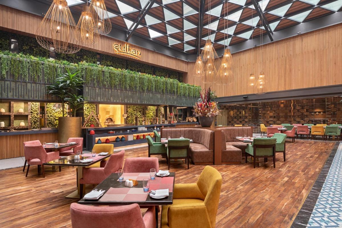 a restaurant with tables and chairs and a bar at Radisson Blu Kaushambi Delhi NCR in Ghaziabad