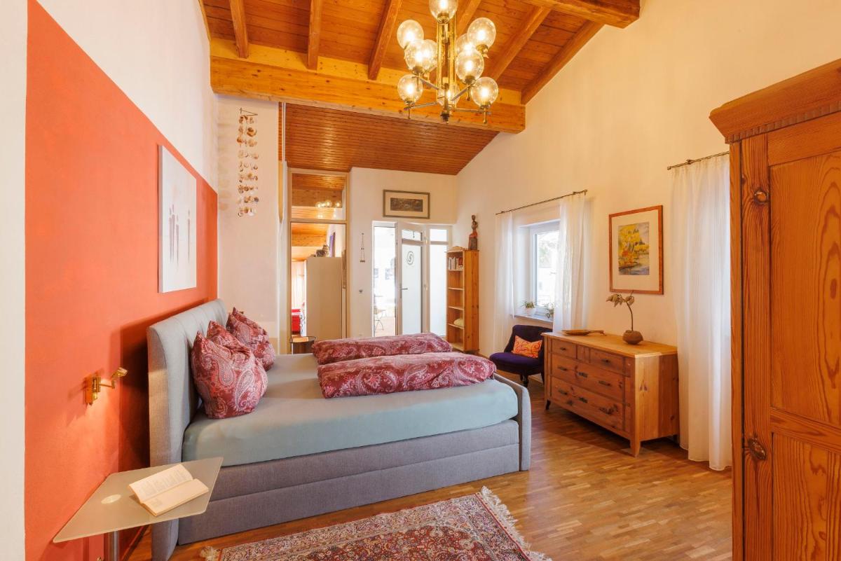 ein Schlafzimmer mit einem Bett mit rosa Kissen darauf in der Unterkunft Haus am Waldpark in Scheidegg