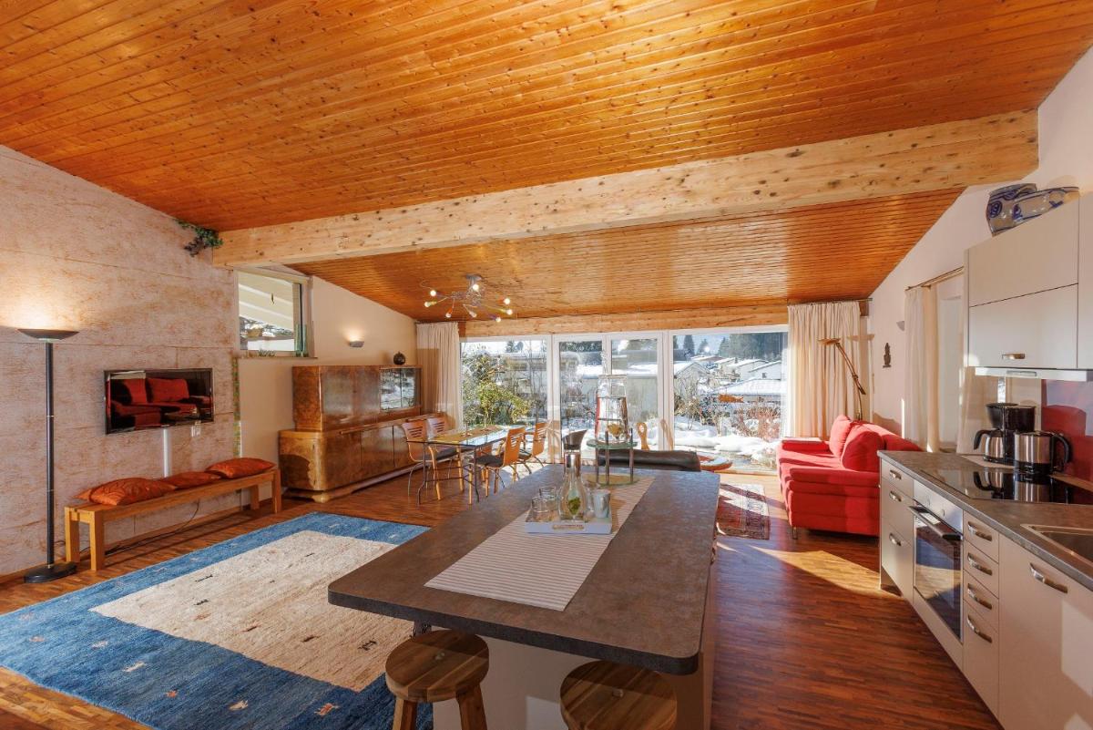 eine Küche und ein Wohnzimmer mit Holzdecke in der Unterkunft Haus am Waldpark in Scheidegg