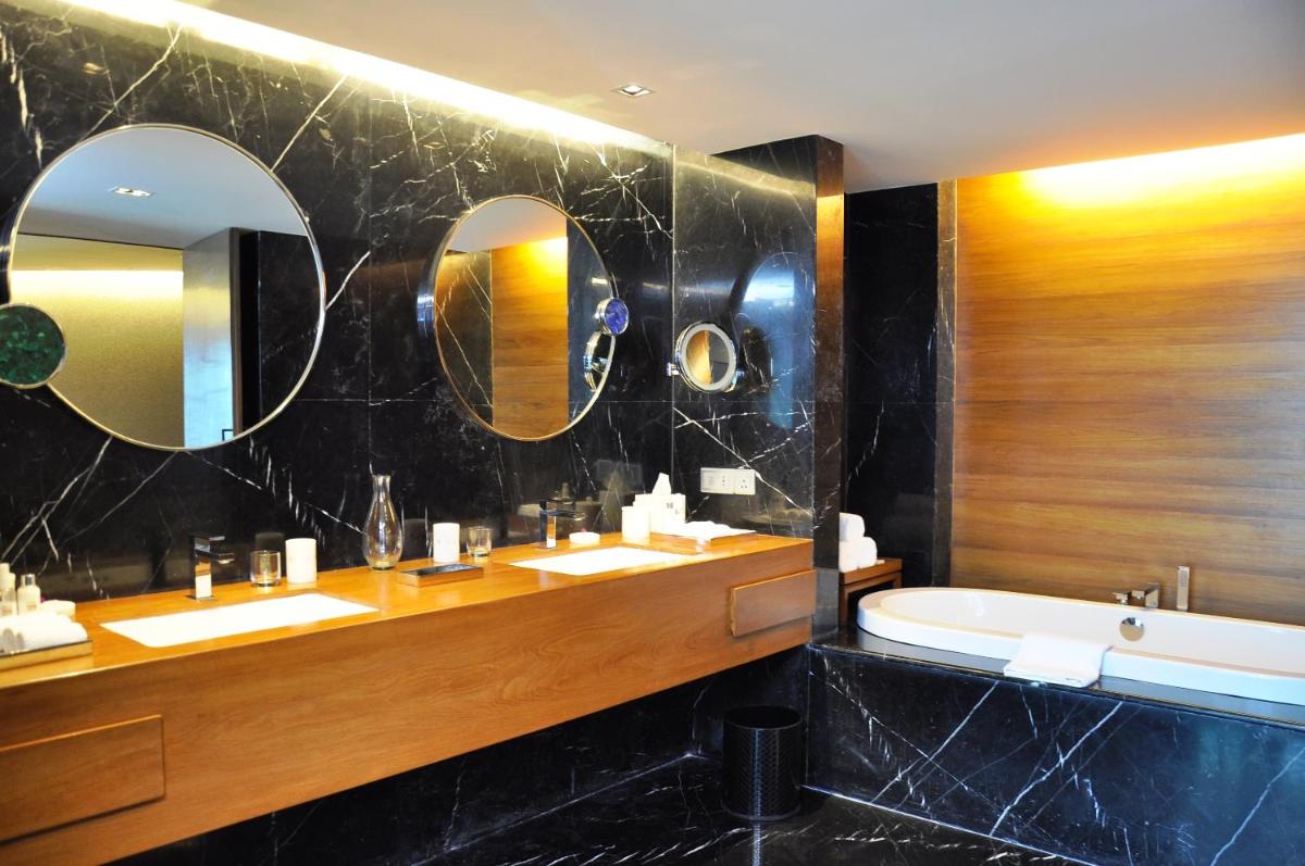 a bathroom with two sinks and a tub and mirrors at The Park Hyderabad, Banjara Hills near Hussain Sagar Lake in Hyderabad a bathroom with two sinks and a tub and mirrors at The Park Hyderabad, Banjara Hills near Hussain Sagar Lake in Hyderabad