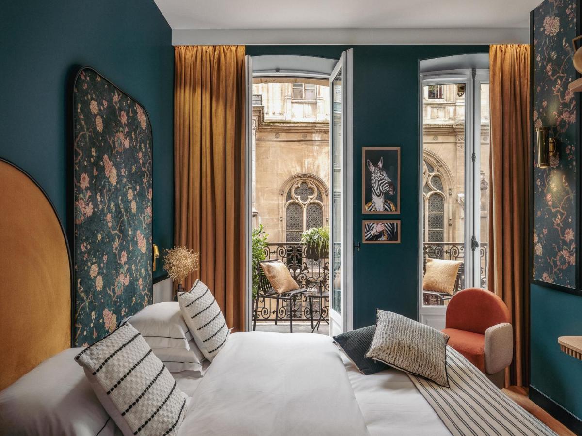 une chambre avec un lit blanc et un balcon dans l'établissement Dandy Hotel, à Paris