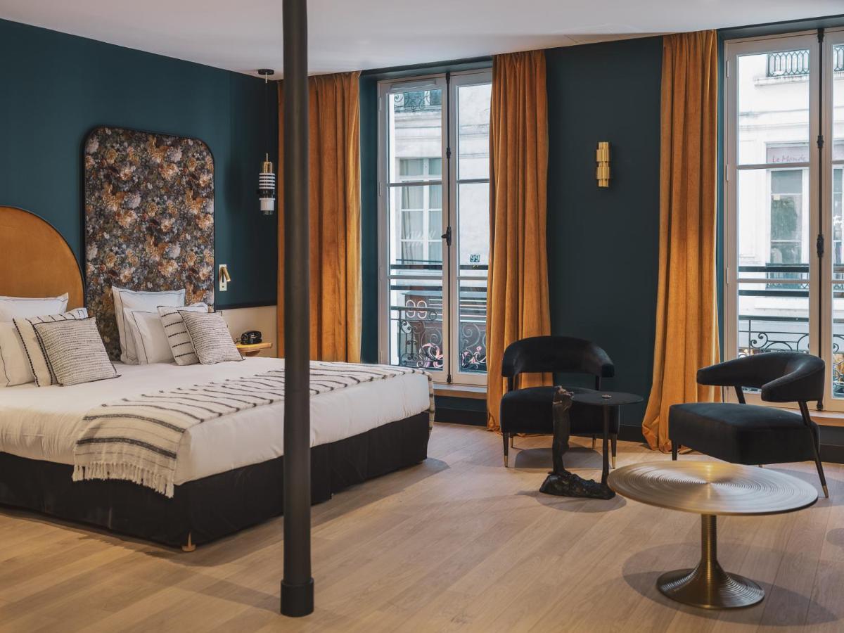 une chambre d'hôtel avec un lit, des chaises et des fenêtres dans l'établissement Dandy Hotel, à Paris 92 autres photos