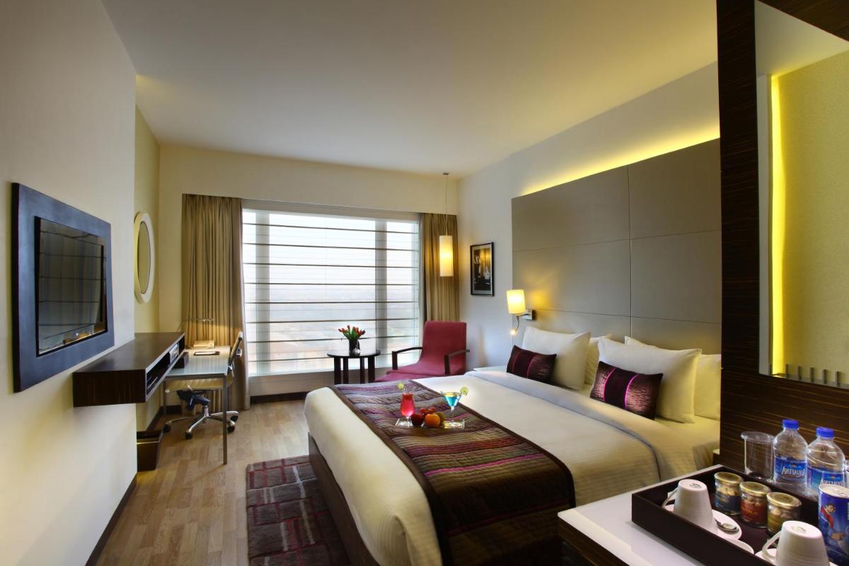 a hotel room with a bed and a desk at Park Plaza Shahdara in New Delhi a hotel room with a bed and a desk at Park Plaza Shahdara in New Delhi