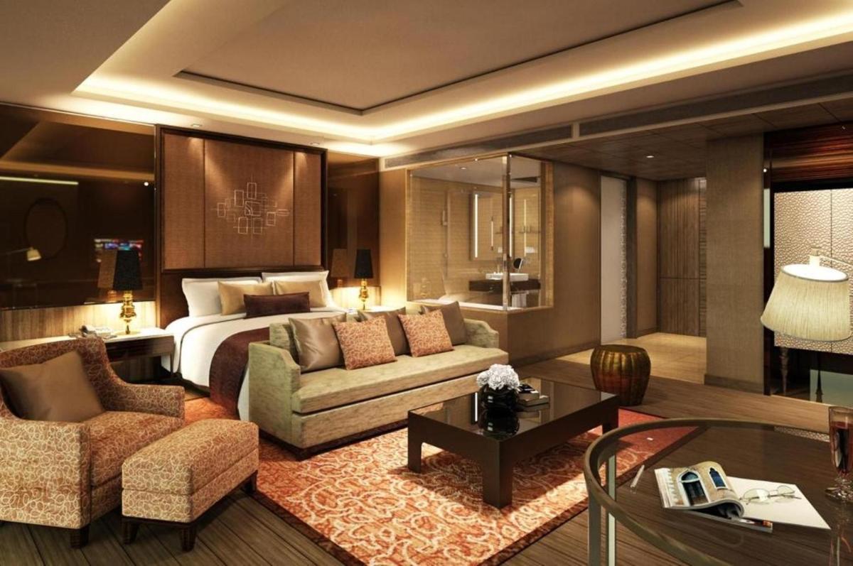 a hotel room with a bed and a living room at Radisson Blu Jaipur in Jaipur