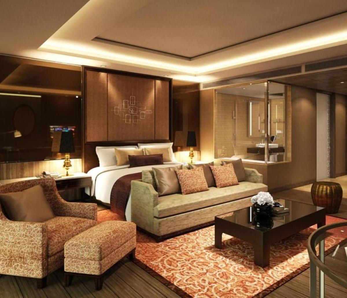 a hotel room with a bed and a couch and chairs at Radisson Blu Jaipur in Jaipur