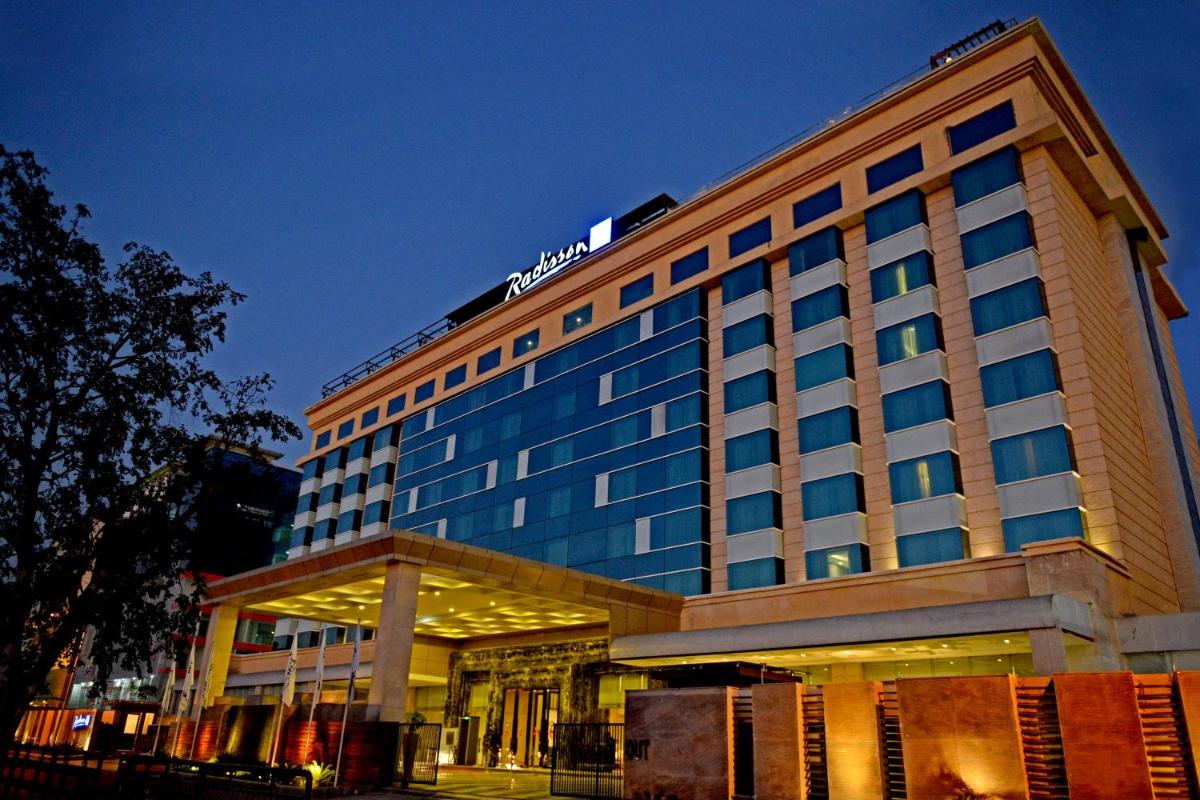 a hotel building with a sign on top of it at Radisson Blu Jaipur in Jaipur