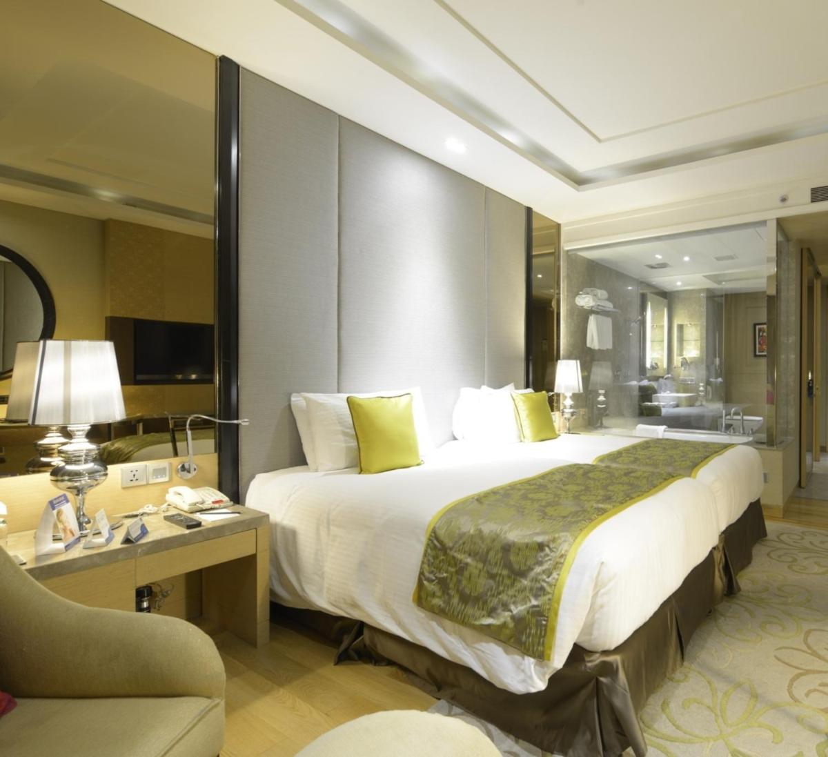 a hotel room with a large bed and a desk at Radisson Blu Jaipur in Jaipur