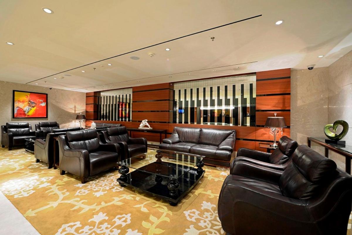 a large living room with leather couches and a table at Radisson Blu Hotel Ahmedabad in Ahmedabad