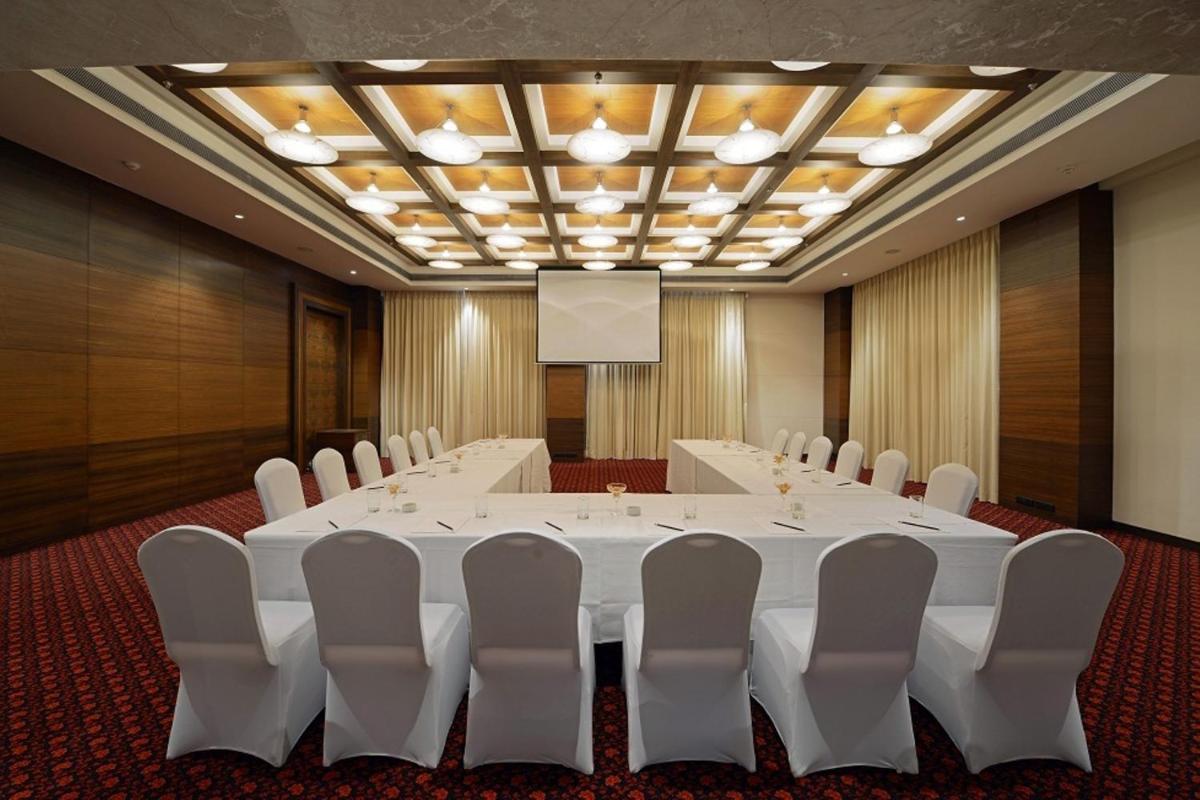 a conference room with a large white table and chairs at Radisson Blu Hotel Ahmedabad in Ahmedabad