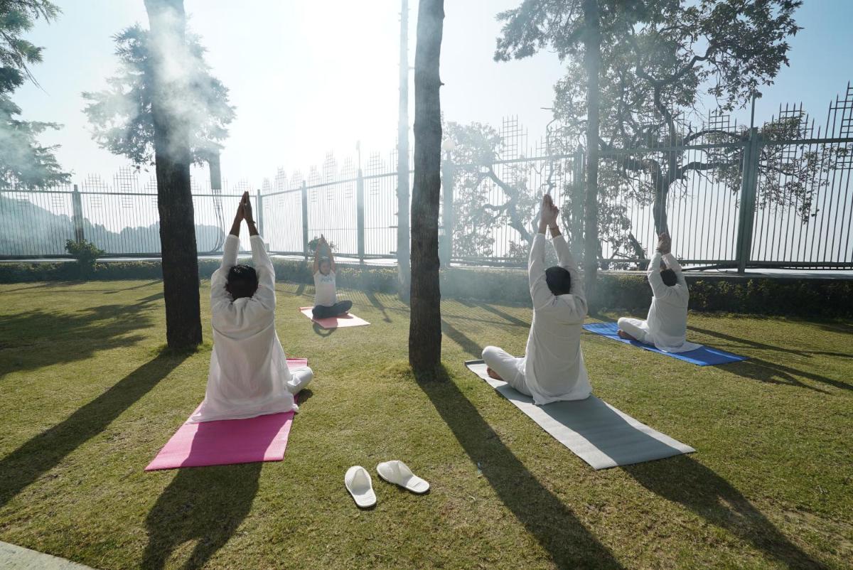 a group of people doing yoga in a park at Jaypee Residency Manor in Mussoorie