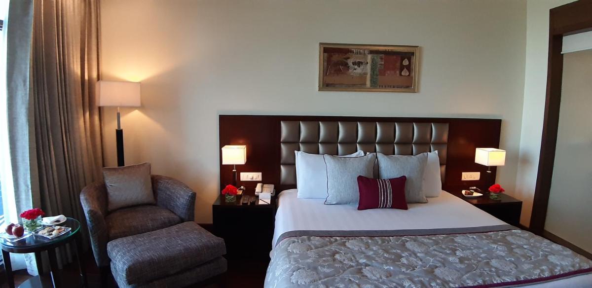 a hotel room with a bed and a chair at Jaypee Residency Manor in Mussoorie