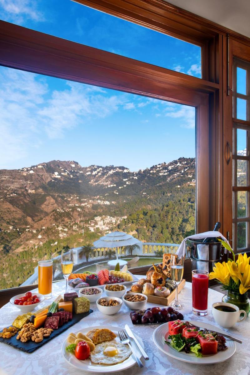 a table full of food with a view of a mountain at Jaypee Residency Manor in Mussoorie