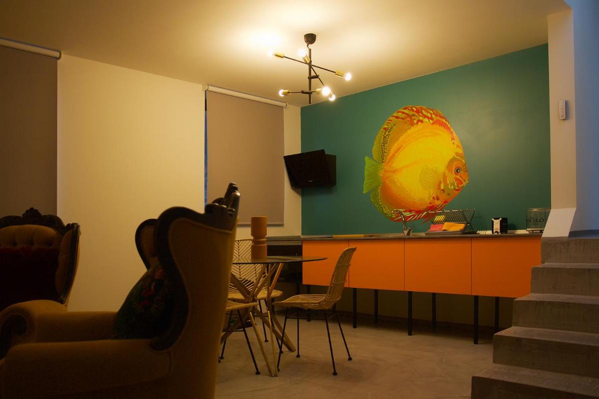 Una sala de estar con mesa y sillas y una cocina. en Hotel Puntagrande, en La Frontera