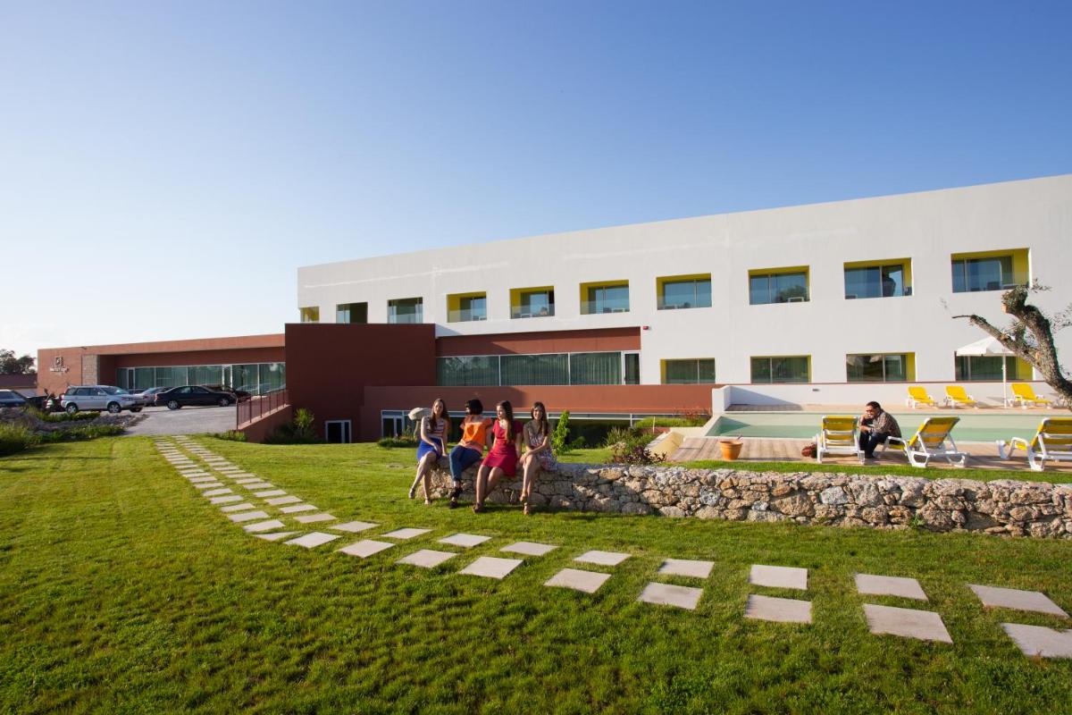 um grupo de pessoas em pé em frente a um prédio em Monte Filipe Hotel no Alpalhão