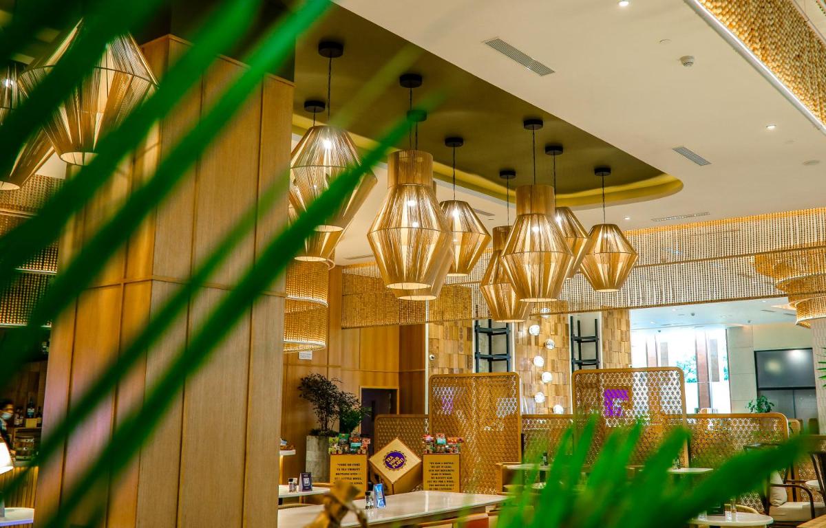 a restaurant with chandeliers hanging from the ceiling at Novotel Hyderabad Airport in Hyderabad