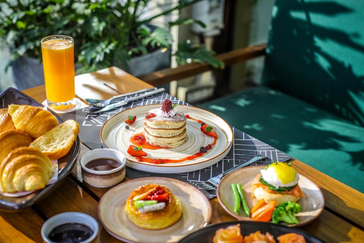 a table with plates of food and a glass of orange juice at Novotel Hyderabad Airport in Hyderabad