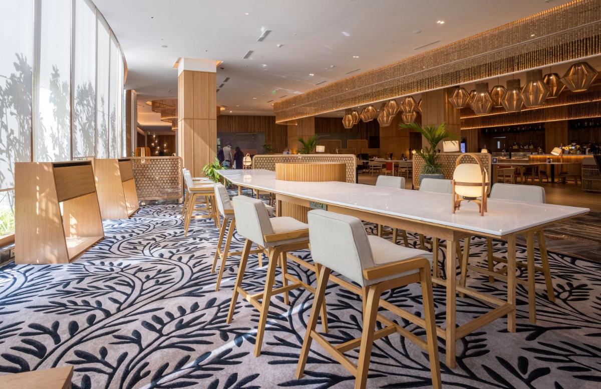 a dining room with a large table and chairs at Novotel Hyderabad Airport in Hyderabad