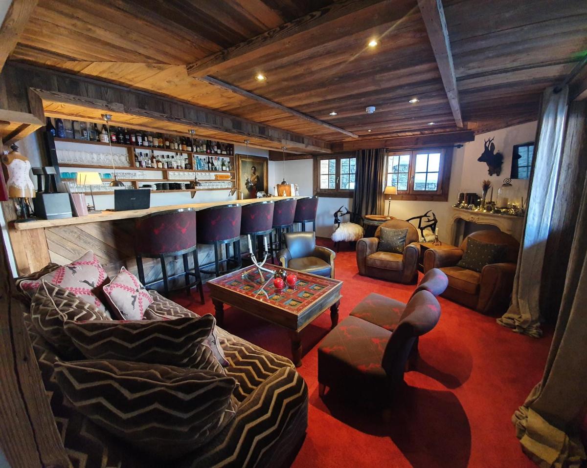 Cette chambre comprend un bar avec des canapés et une table. dans l'établissement Le Chalet Blanc, à Megève Cette chambre comprend un bar avec des canapés et une table. dans l'établissement Le Chalet Blanc, à Megève