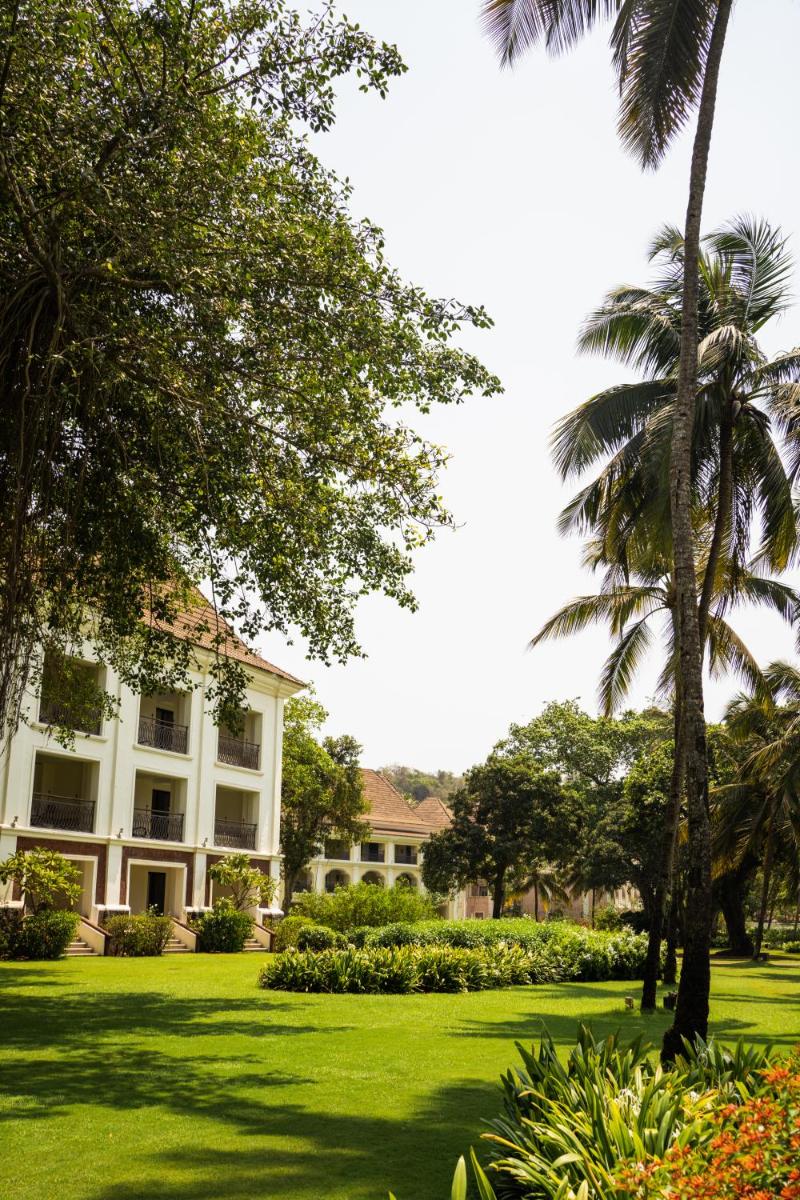 a large white building with palm trees and a yard at Grand Hyatt Goa in Panaji a large white building with palm trees and a yard at Grand Hyatt Goa in Panaji