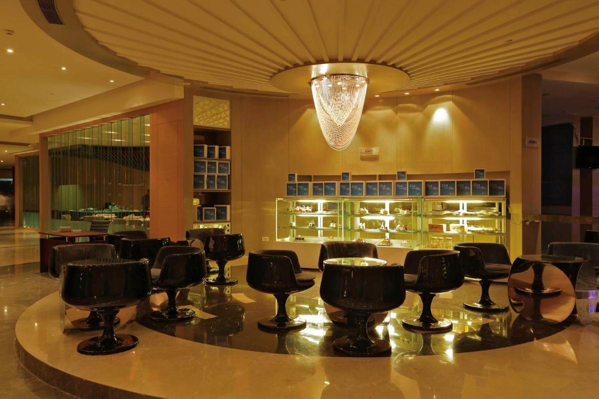 a bar in a restaurant with black bar stools at Yashail Hotel Haridwar in Haridwār
