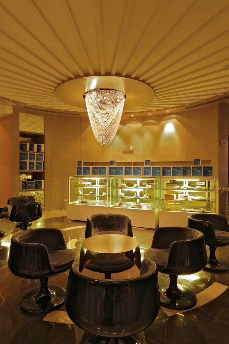 a lobby with chairs and a table and a chandelier at Yashail Hotel Haridwar in Haridwār