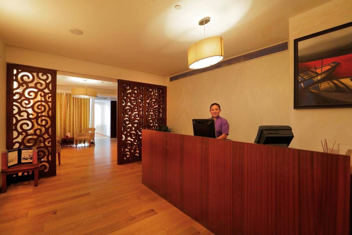 a man standing at a reception desk in a hotel room at Yashail Hotel Haridwar in Haridwār