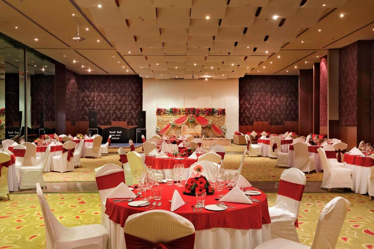 a banquet hall with white tables and white chairs at Yashail Hotel Haridwar in Haridwār