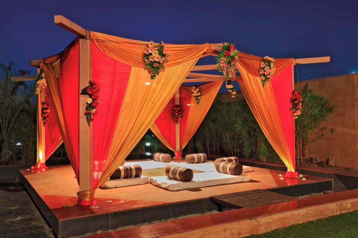 a stage with a red curtain and some food at Yashail Hotel Haridwar in Haridwār