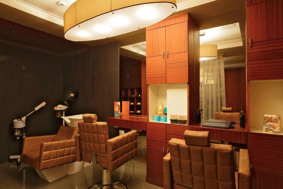 a room with a hair salon with chairs and a mirror at Yashail Hotel Haridwar in Haridwār