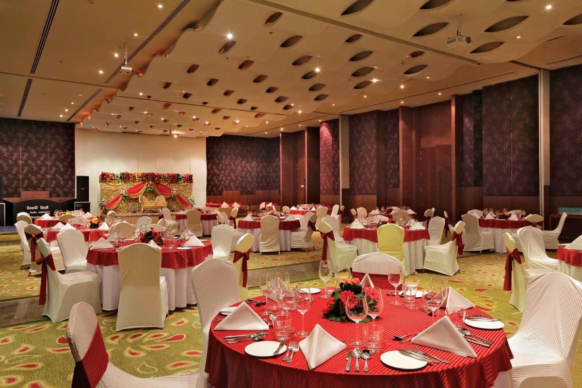 a banquet hall with red and white tables and chairs at Yashail Hotel Haridwar in Haridwār