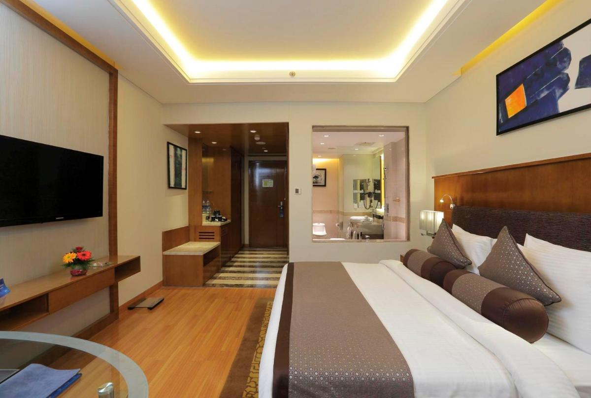 a bedroom with a large bed and a television at Yashail Hotel Haridwar in Haridwār