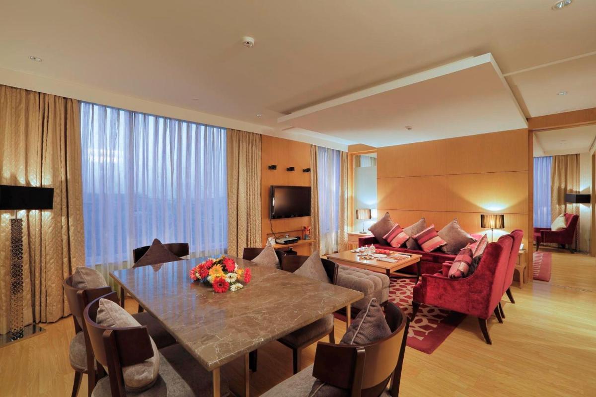 a hotel room with a dining table and a living room at Yashail Hotel Haridwar in Haridwār
