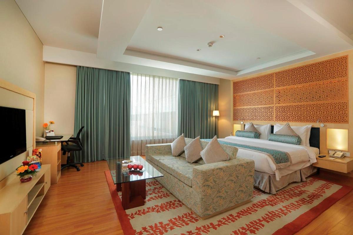 a hotel room with a bed and a couch at Yashail Hotel Haridwar in Haridwār