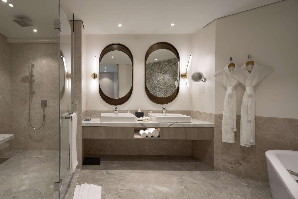 a bathroom with two sinks and two mirrors at Radisson Blu Mumbai International Airport in Mumbai