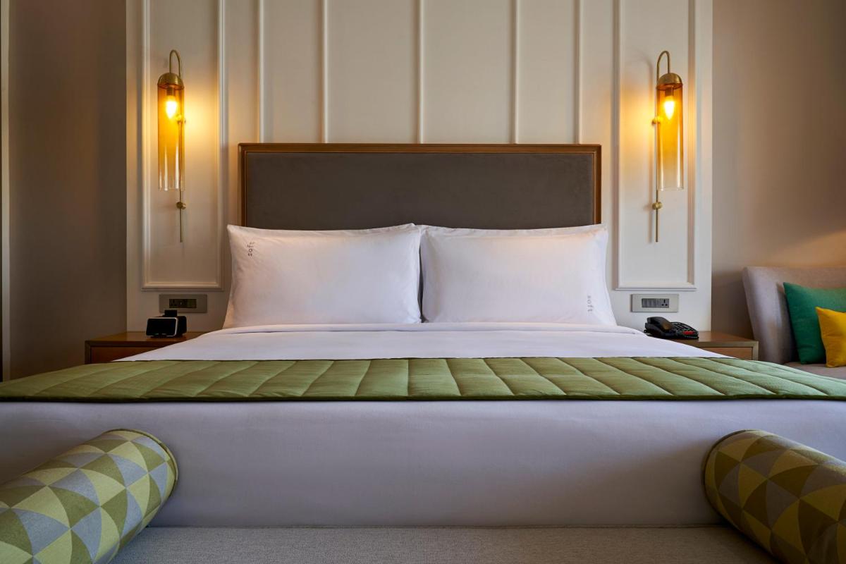 a bedroom with a large bed with white pillows at Holiday Inn Goa Candolim in Candolim a bedroom with a large bed with white pillows at Holiday Inn Goa Candolim in Candolim