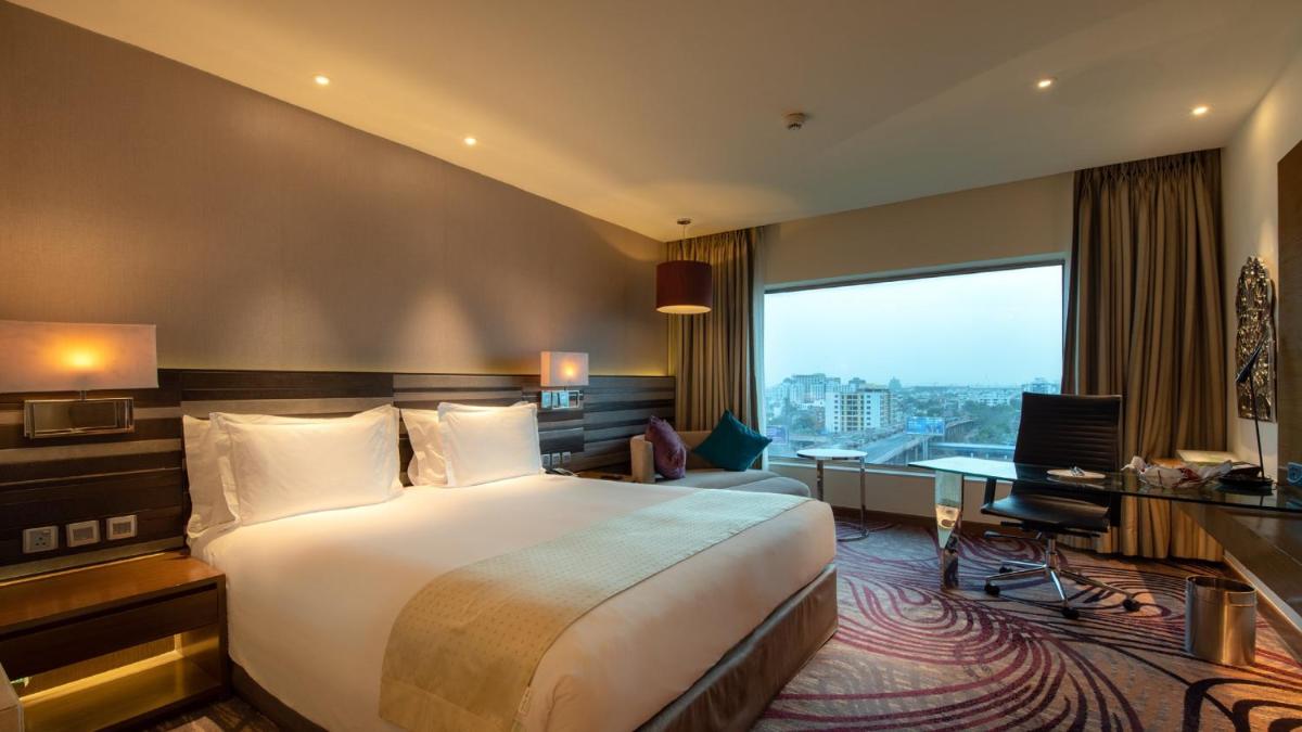 a hotel room with a bed and a desk at Holiday Inn Jaipur City Centre by IHG in Jaipur a hotel room with a bed and a desk at Holiday Inn Jaipur City Centre by IHG in Jaipur