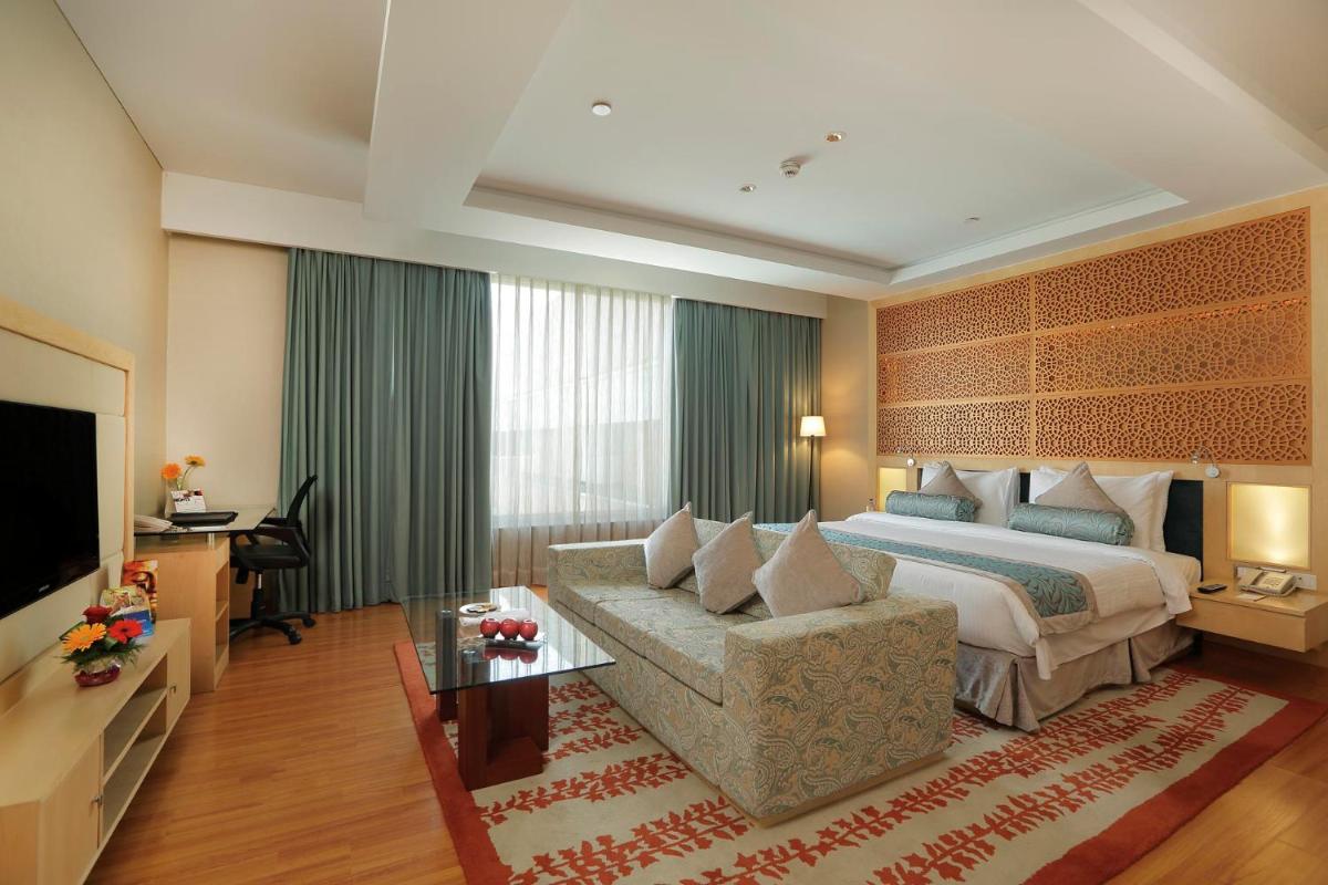 a hotel room with a bed and a couch at Yashail Hotel Haridwar in Haridwār