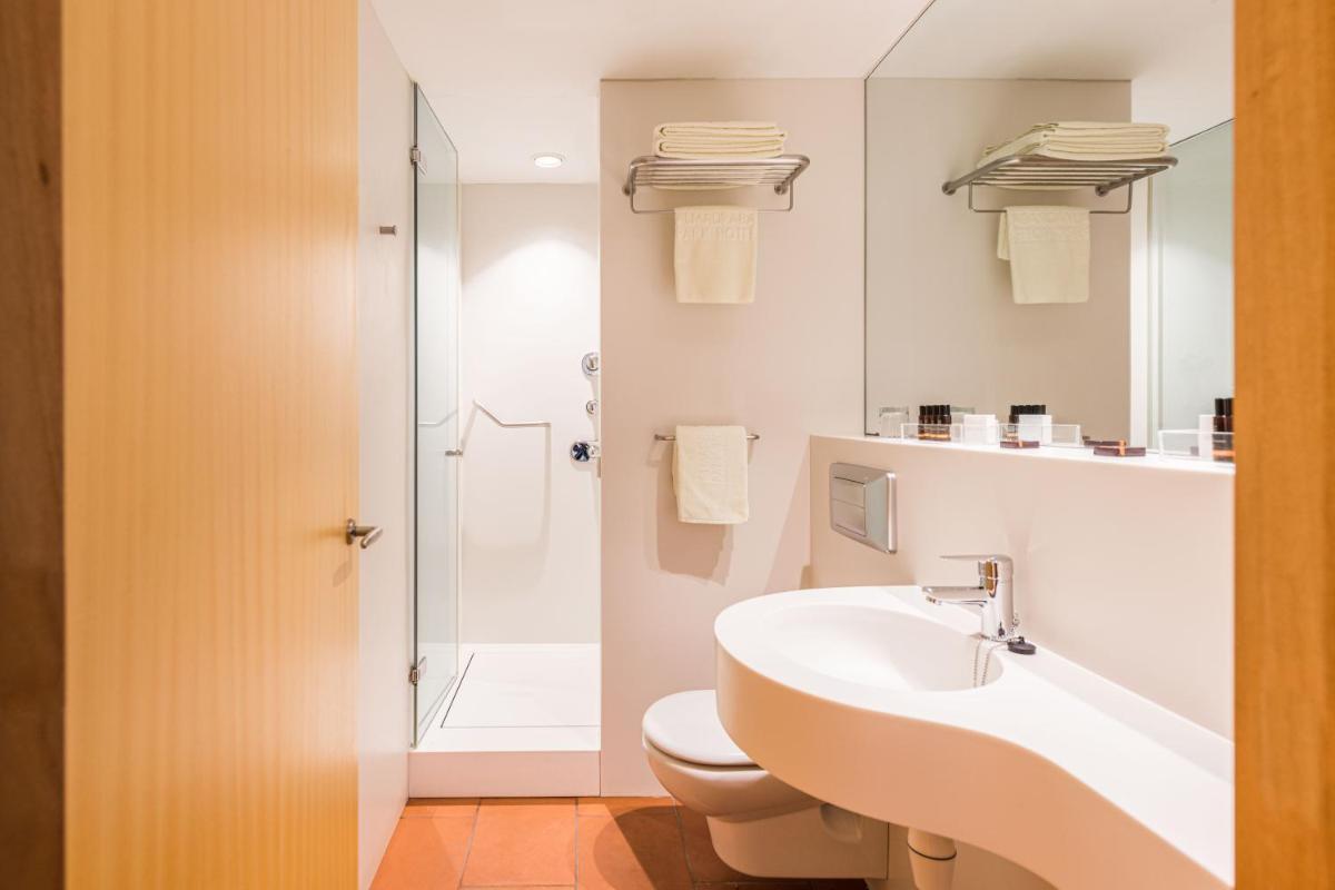 Un baño con lavabo, inodoro y ducha. en Almadraba Park Hotel, en Roses
