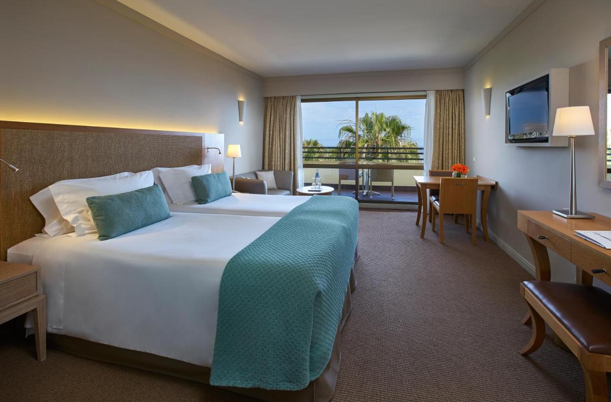 um quarto de hotel com uma cama grande e uma escrivaninha em Suite Hotel Eden Mar - PortoBay no Funchal