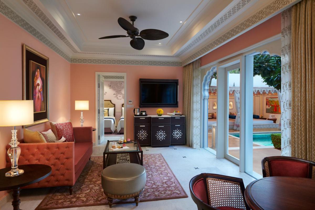 a living room with a couch and a tv at The Leela Palace Jaipur in Jaipur