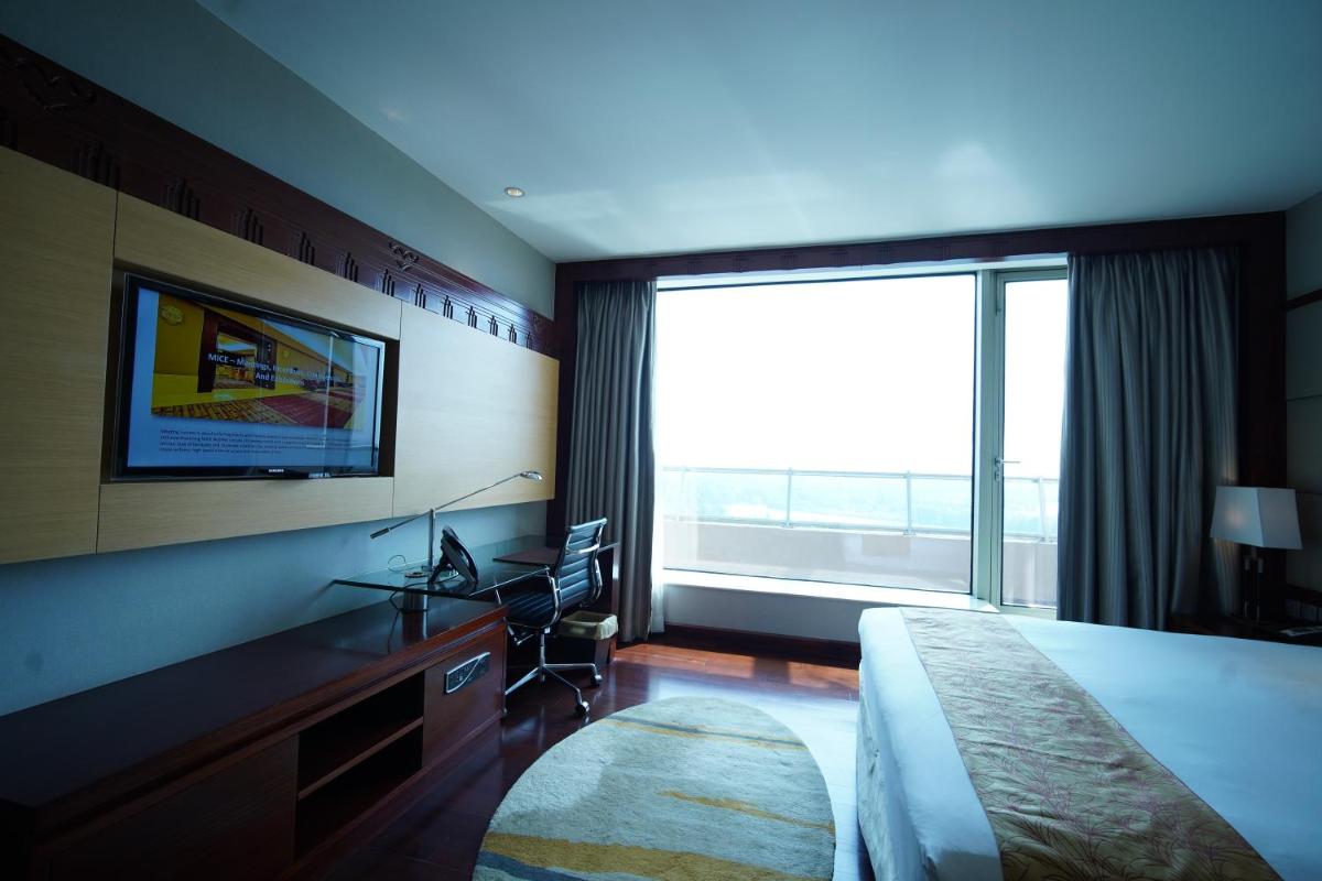 a hotel room with a bed and a large window at Crowne Plaza Kochi by IHG in Cochin