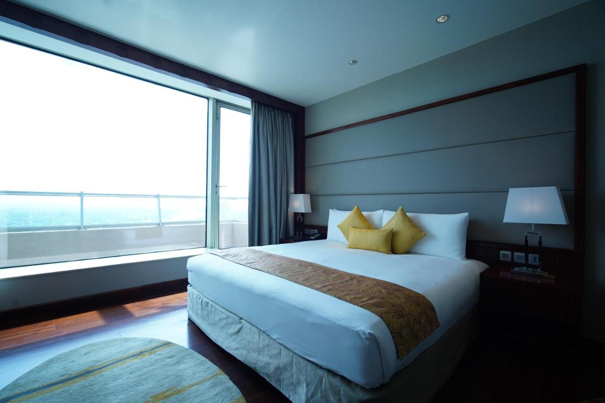 a bedroom with a large bed and a large window at Crowne Plaza Kochi by IHG in Cochin