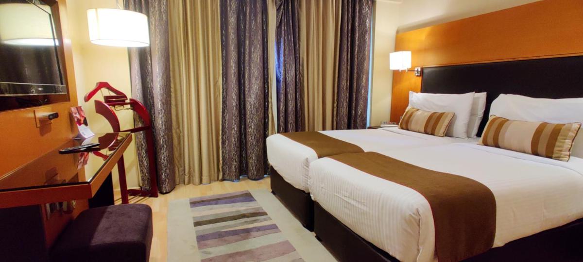 a hotel room with a large bed and a television at Turyaa Chennai - OMR IT Expressway in Chennai
