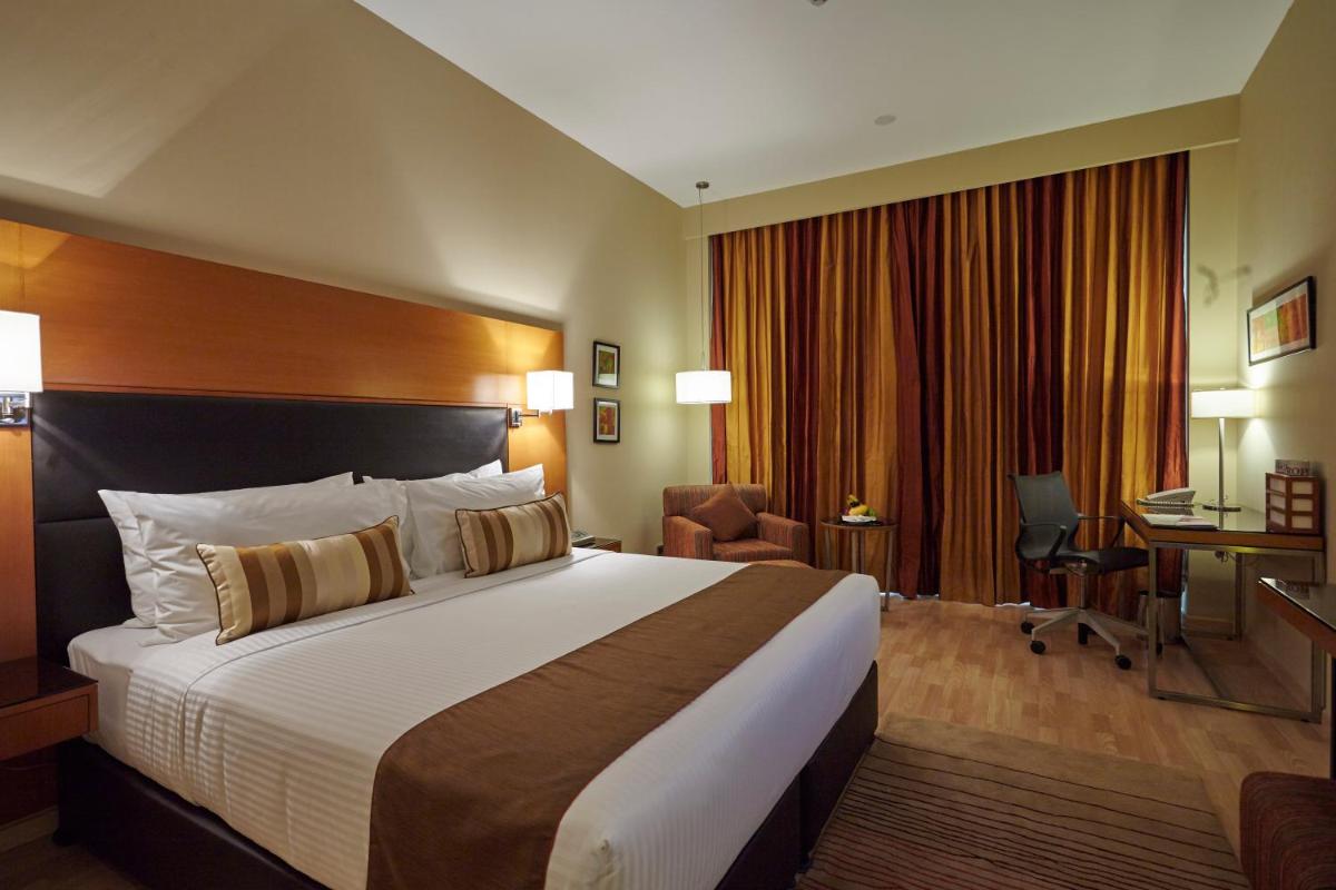 a hotel room with a large bed and a desk at Turyaa Chennai - OMR IT Expressway in Chennai