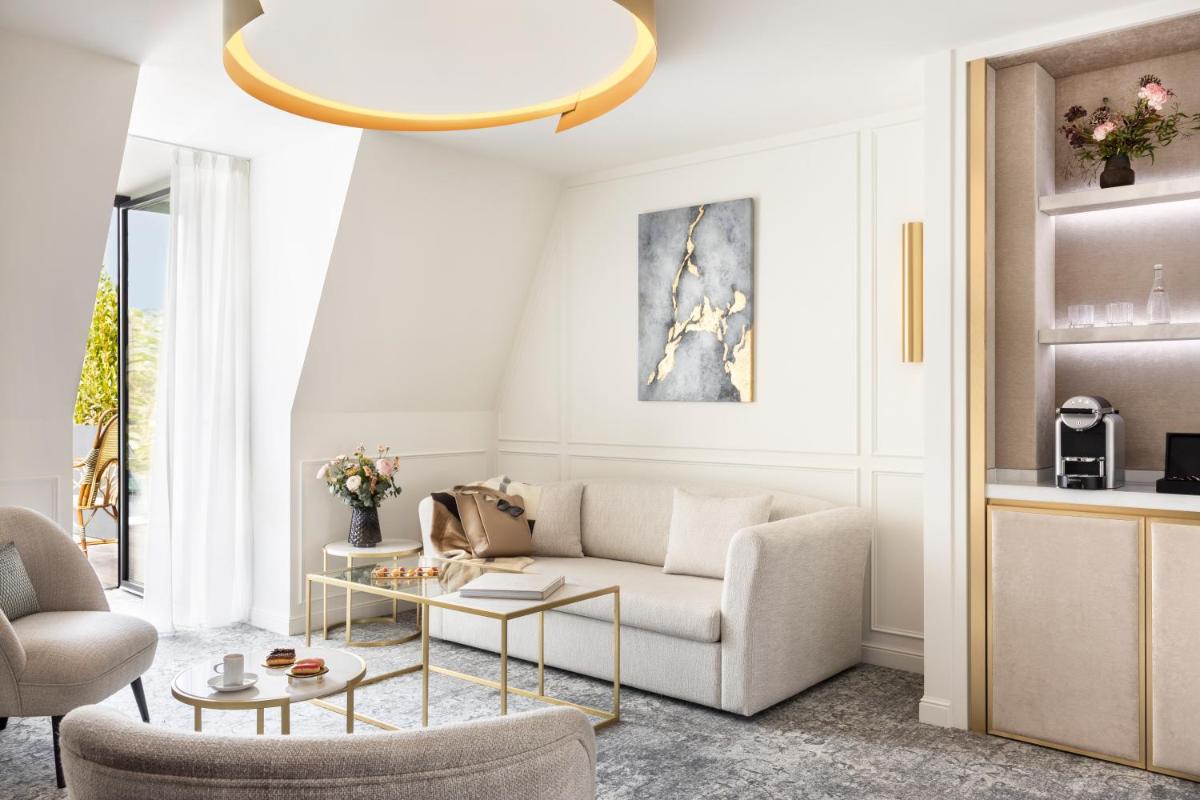 un salon avec un canapé et une table dans l'établissement Maison Albar - Le Vendome, à Paris
